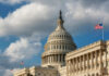 Capitol Meltdown Over FISA And Voting The U.S. Capitol building with a dome and an American flag under a cloudy sky