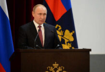 Is Moscow Bluffing With Nuclear Threats? A government official delivering a speech at a podium with national flags in the background