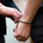 Man Flees Crash, Leaves Child Behind A close-up of a person being handcuffed by an officer