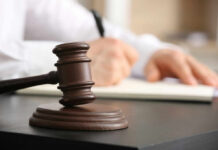 Free Speech Showdown: ICE Gets Overruled A gavel on a desk with a blurred hand writing in the background