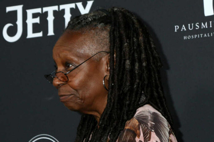 Profile portrait of a woman with dreadlocks wearing glasses at a red carpet event