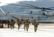 America’s Hidden Weapons Depot Down Under Marines in combat gear walking towards a helicopter