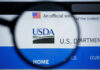 USDA Uncovers Millions in Fraud—Claims Remain Unproven Close-up view of the USDA website logo through a magnifying glass