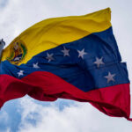 Venezuelan flag waving against a blue sky