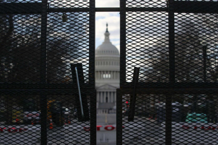 shutterstock_2153264849 View of the Capitol building through a security fence
