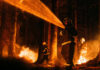 Firefighters battling a forest fire at night