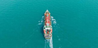 Aerial view of a cargo ship navigating through turquoise waters