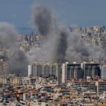Smoke rising from buildings in a densely populated urban area