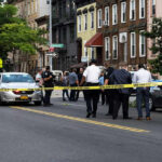 Homan TORCHES Doubters Over NYC Blast Police gathered at an urban crime scene.