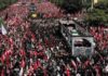 Iran’s Delayed Funeral Sparks Debate Massive funeral procession with coffins on a vehicle amid a sea of mourners