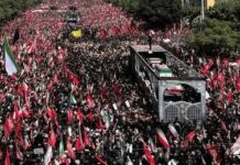 Iran’s Delayed Funeral Sparks Debate Massive funeral procession with coffins on a vehicle amid a sea of mourners