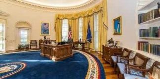 Oval office with wooden desk, blue rug, and gold curtains