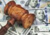 Legal Aid Founder’s Luxury Life Exposed Wooden judge's gavel on scattered US dollar bills