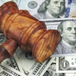 Wooden judge's gavel on scattered US dollar bills