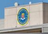 DOJ Battles Maryland Over College Benefits FBI emblem on a beige building facade