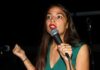 AOC Targets Senate, Raises Eyebrows Again Woman speaking into a microphone on stage
