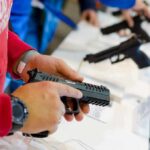 State Court Defies SCOTUS On Guns person handling a handgun at a display counter