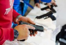 State Court Defies SCOTUS On Guns person handling a handgun at a display counter