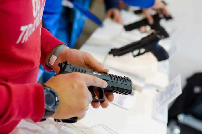 shutterstock_1207070692 person handling a handgun at a display counter