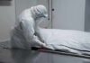 Diary Reveals Alleged Rapists After Euthanasia Healthcare worker in PPE zipping a body bag on a gurney