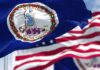 Judge Slaps Virginia’s Mask Crackdown Virginia state flag waving in the foreground with an American flag in the background