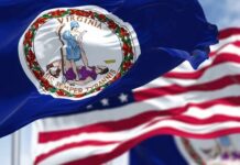 Judge Slaps Virginia’s Mask Crackdown Virginia state flag waving in the foreground with an American flag in the background