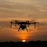 Cuba’s Drone Build-Up Raises Alarms A drone flying against a sunset sky, silhouetted by the evening light