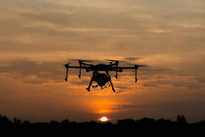 shutterstock_2480271581 A drone flying against a sunset sky, silhouetted by the evening light