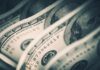 Rich Donors Quietly Rewrite Childhood Close-up of folded hundred dollar bills