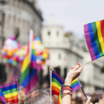 Why Does Seattle Need Emergency Powers? Crowd holding rainbow flags at a Pride parade