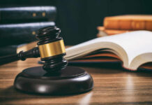 Justice Department Reversed Course Quietly Judge's gavel on desk with open law book