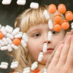 Senator Targets Plan C Over Abortion Pills A child observing colorful pills floating in the air