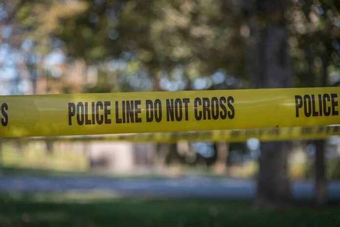 shutterstock_1019810653 yellow police tape cordoning off an outdoor area