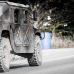 Drone Swarms Meet Electric Doom Military vehicle driving on a rural road