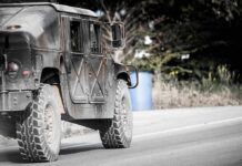 Drone Swarms Meet Electric Doom Military vehicle driving on a rural road