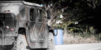 Military vehicle driving on a rural road