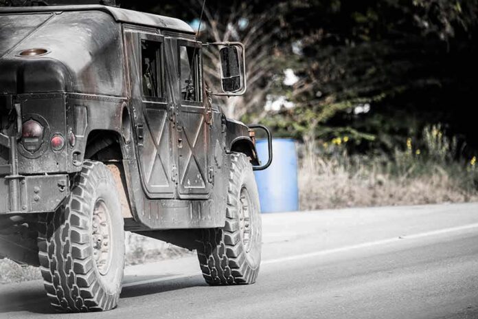 shutterstock_1021443394 Military vehicle driving on a rural road