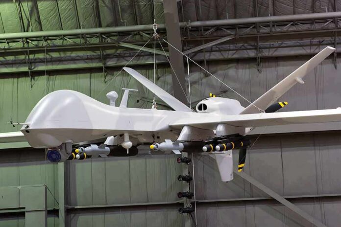 shutterstock_1093736552 military drone with missiles suspended in a hangar