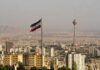 U.S. Targets Iran Financial Network Iranian flag over Tehran skyline with Milad Tower