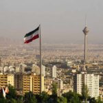 Iranian flag over Tehran skyline with Milad Tower