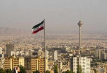 Iranian flag over Tehran skyline with Milad Tower