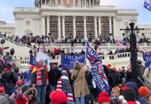 Trump Handled This Heckler Beautifully! Crowd with flags gathered outside a large white government building