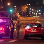 Traffic Stop Unmasks A Deadlier Truth Security officers stop a red taxi at a night checkpoint