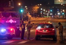 Traffic Stop Unmasks A Deadlier Truth Security officers stop a red taxi at a night checkpoint