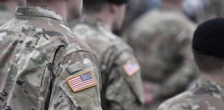 Soldiers in camouflage uniforms with U.S. flag patches