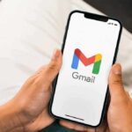 Inbox Nightmare: Political Blasts Incoming Hands holding a smartphone displaying the Gmail app logo