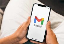 Hands holding a smartphone displaying the Gmail app logo