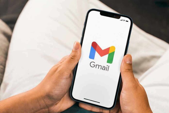 Hands holding a smartphone displaying the Gmail app logo