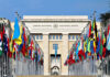 War Crimes Alarm Rattles U.S. And Iran United Nations building with numerous national flags outside.