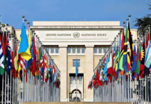 War Crimes Alarm Rattles U.S. And Iran United Nations building with numerous national flags outside.
